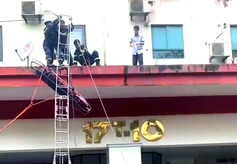 Lực lượng Cảnh sát PCCC và CNCH cố định nạn nhân vào cáng để đưa xuống mặt đất an toàn