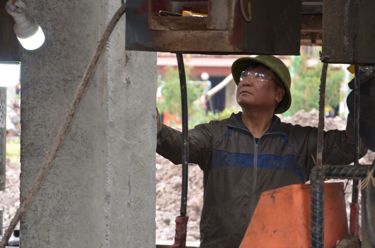 Các công nhân đang thực hiện việc ép cọc để làm móng tại vị trí cột thuộc xã Kim Định (huyện Kim Sơn), đây là vị trí cuối cùng tại Ninh Bình để vượt sông Đáy sang địa bàn tỉnh Nam Định. Ảnh: Nguyễn Trường