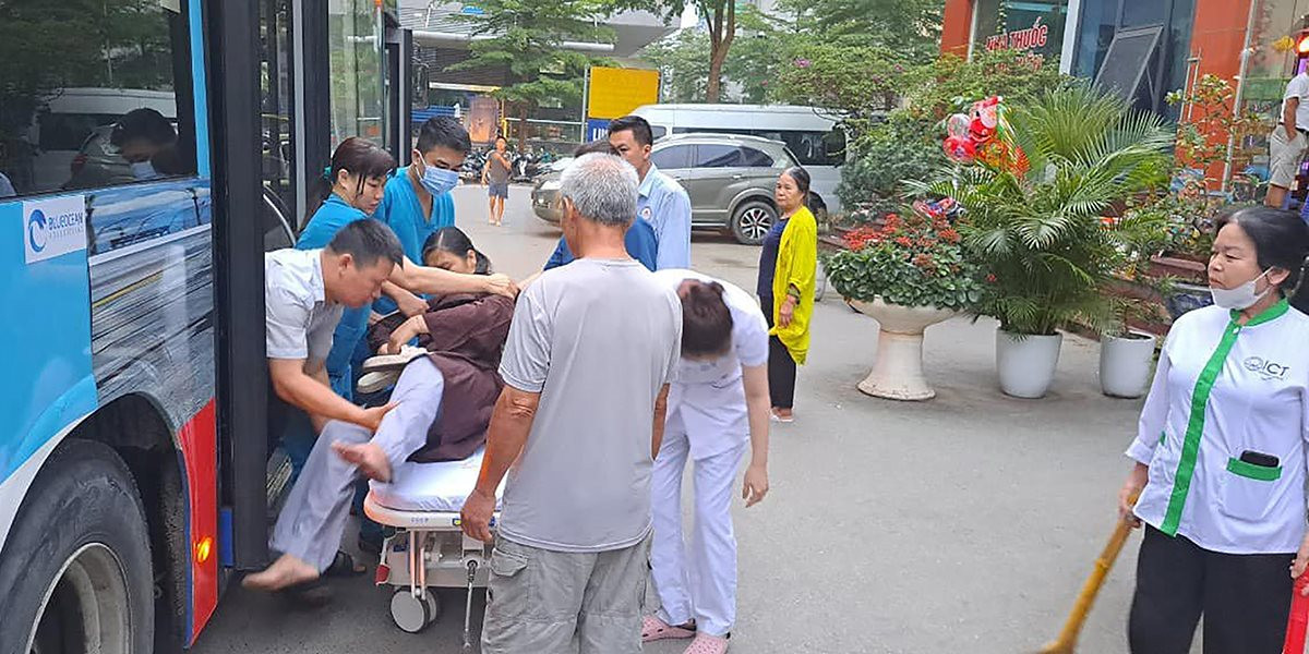Lái xe Trần Văn Phong và nhân viên bán vé Nguyễn Văn Hùng đưa nữ hành khách ngất xỉu trên tuyến xe 62 vào Bệnh viện Đa khoa Nông nghiệp (ngày 14-4).