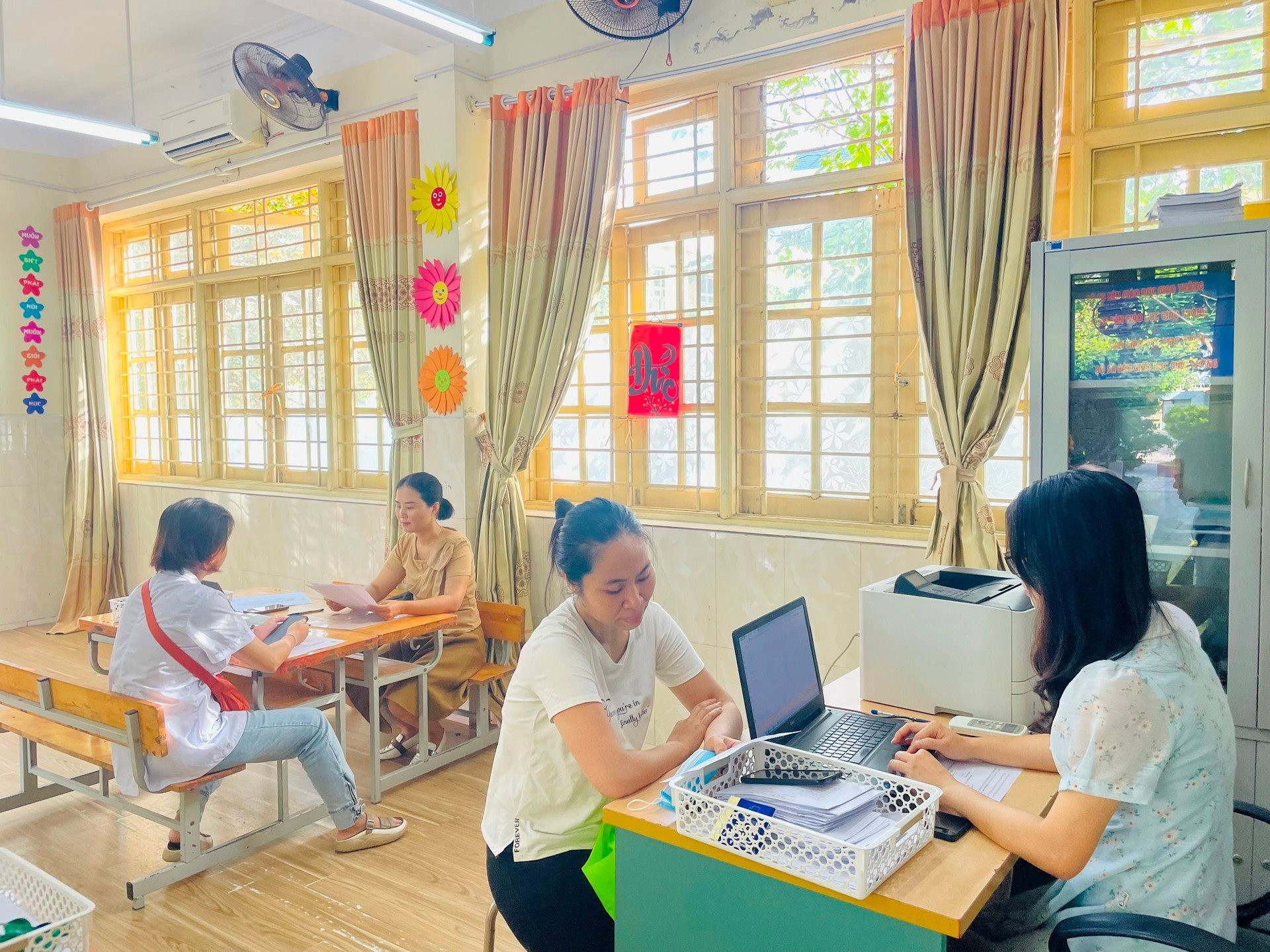 Giáo viên Trường Tiểu học Văn Yên (quận Hà Đông) hỗ trợ cha mẹ học sinh đăng ký tuyển sinh lớp 1 năm học 2023-2024. Ảnh: Thống Nhất