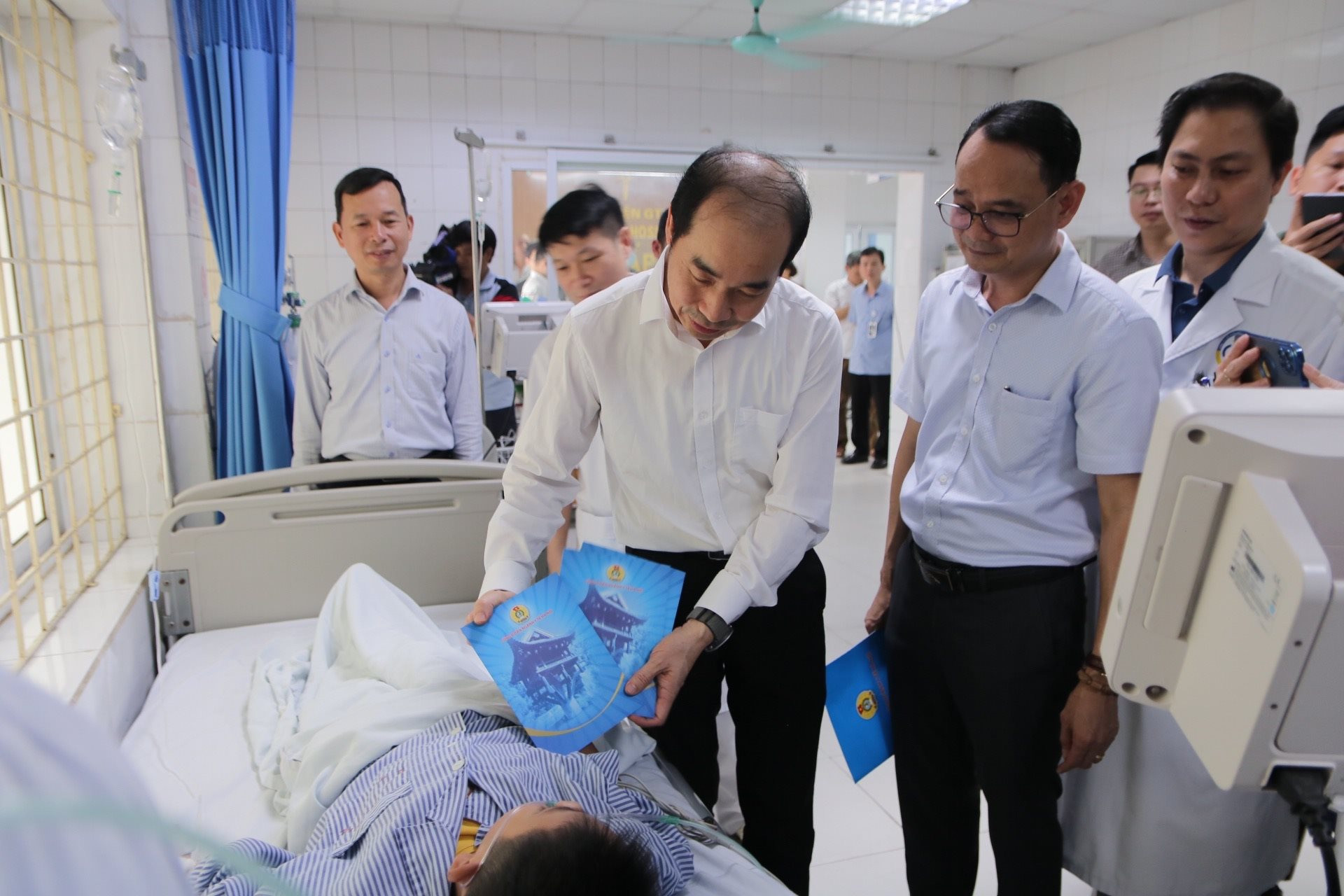 Ông Nguyễn Đình Hưng, Phó Giám đốc phụ trách Sở Y tế Hà Nội trao quà cho các bệnh nhân vụ cháy. Ảnh: Duy Tuân