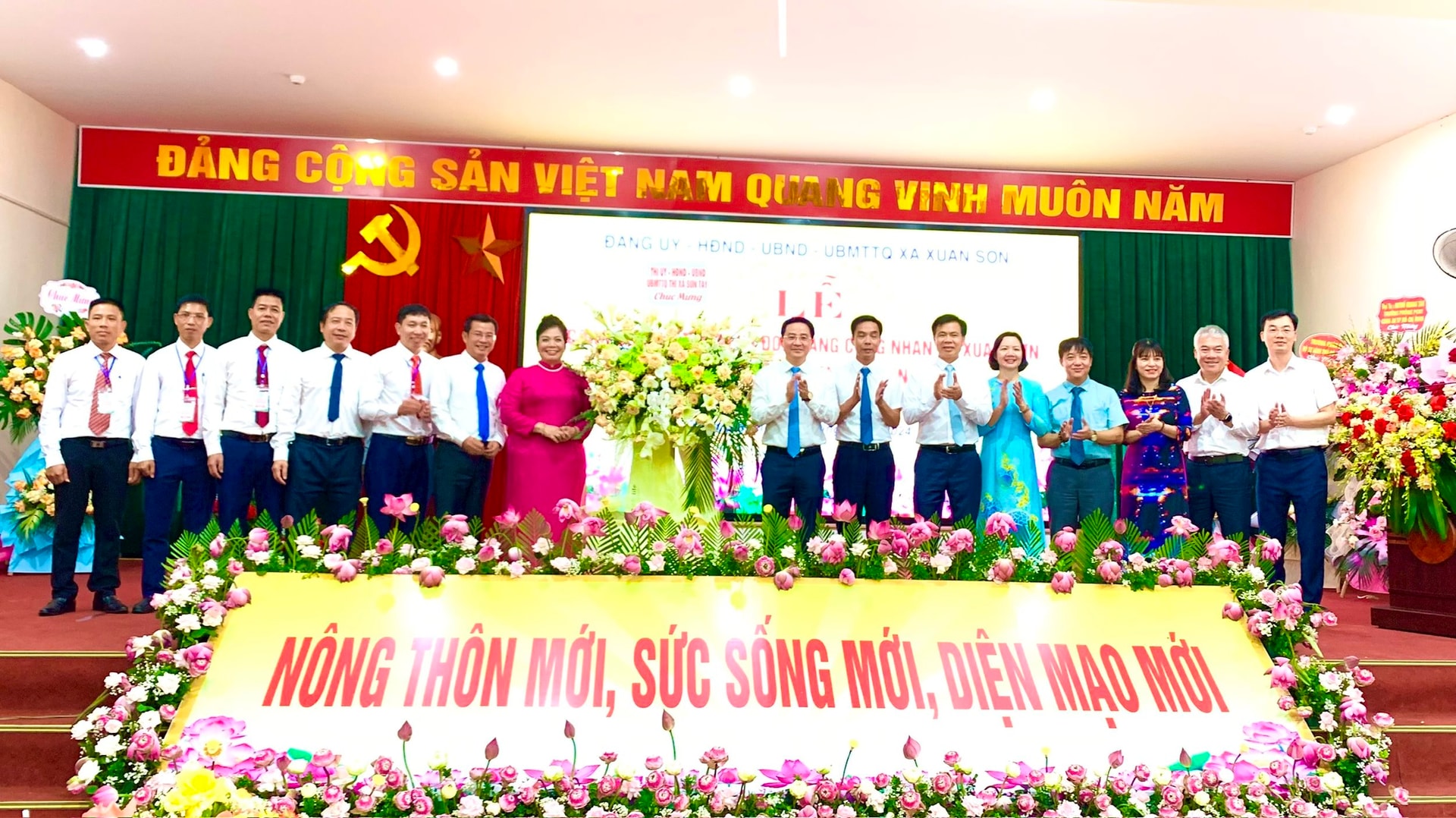 Lãnh đạo Thị ủy, HĐND, UBND, Ủy ban MTTQ Việt Nam thị xã Sơn Tây tặng hoa chúc mừng xã Xuân Sơn. Ảnh: Ánh Dường,