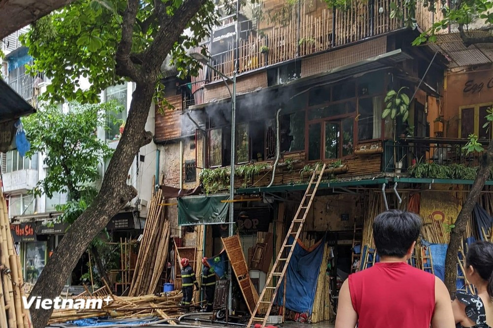 Lực lượng chức năng nhanh chóng dập tắt đám cháy trên phố Hàng Vải (Hoàn Kiếm, Hà Nội). (Ảnh: PV/Vietnam+)