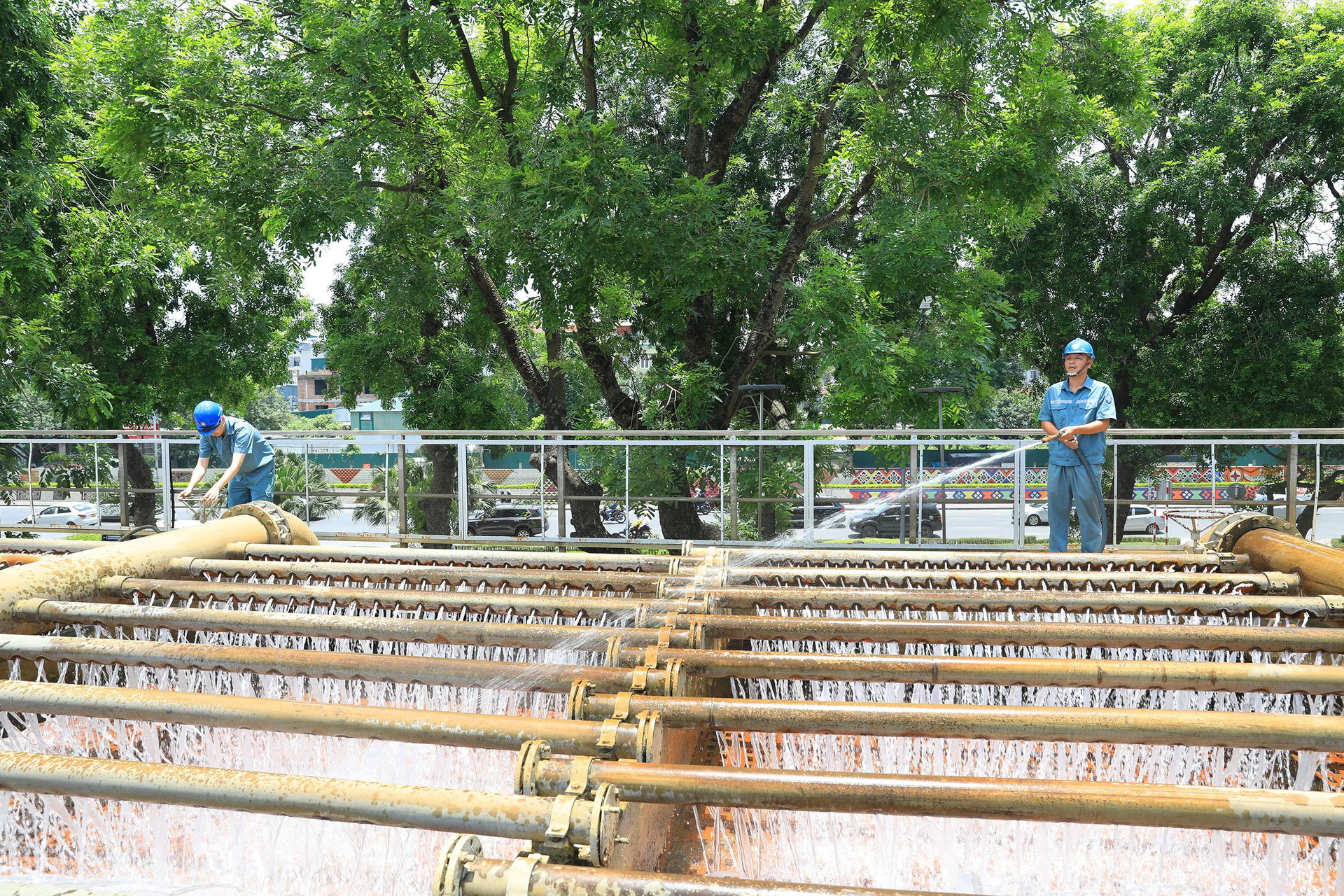 Các công nhân vệ sinh dàn mưa của Nhà máy nước Yên Phụ (quận Ba Đình).