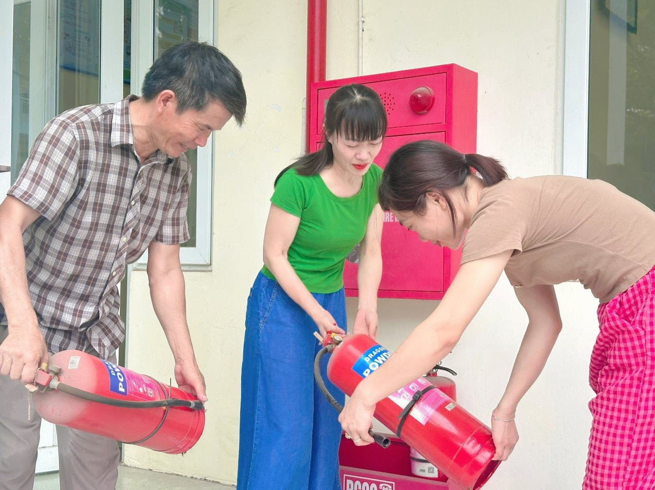 Giáo viên, nhân viên Trường THCS Tiền Phong (huyện Mê Linh) kiểm tra thiết bị phòng cháy, chữa cháy chuẩn bị cho kỳ thi tốt nghiệp THPT năm 2024. Ảnh: Thống Nhất