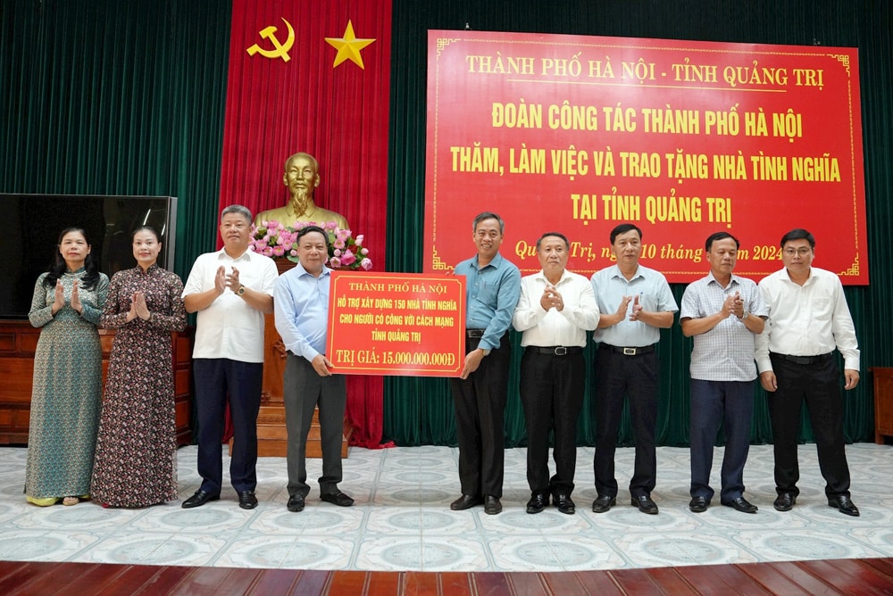 Phó Bí thư Thành ủy Hà Nội Nguyễn Văn Phong trao biển tượng trưng tặng 150 nhà tình nghĩa cho đại diện lãnh đạo tỉnh Quảng Trị. Ảnh: Mai Hoa