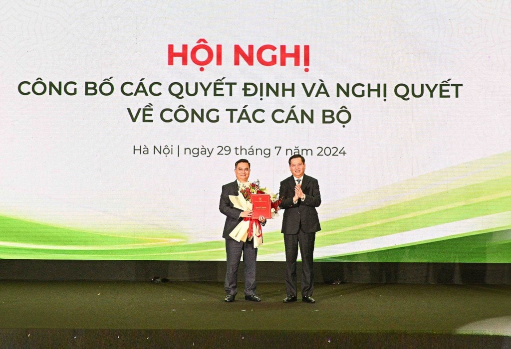 Ông Nguyễn Long Hải - Ủy viên dự khuyết BCH Trung ương Đảng, Bí thư Đảng ủy Khối DNTW (bên phải) trao Quyết định và tặng hoa chúc mừng ông Nguyễn Thanh Tùng, tân Bí thư Đảng ủy Vietcombank