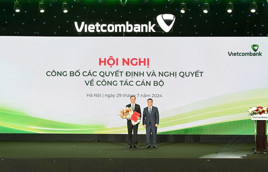  3 / 8  Ông Nguyễn Thanh Tùng - Bí thư Đảng ủy, Chủ tịch HĐQT Vietcombank (bên phải) trao Quyết định và tặng hoa chúc mừng ông Lê Quang Vinh