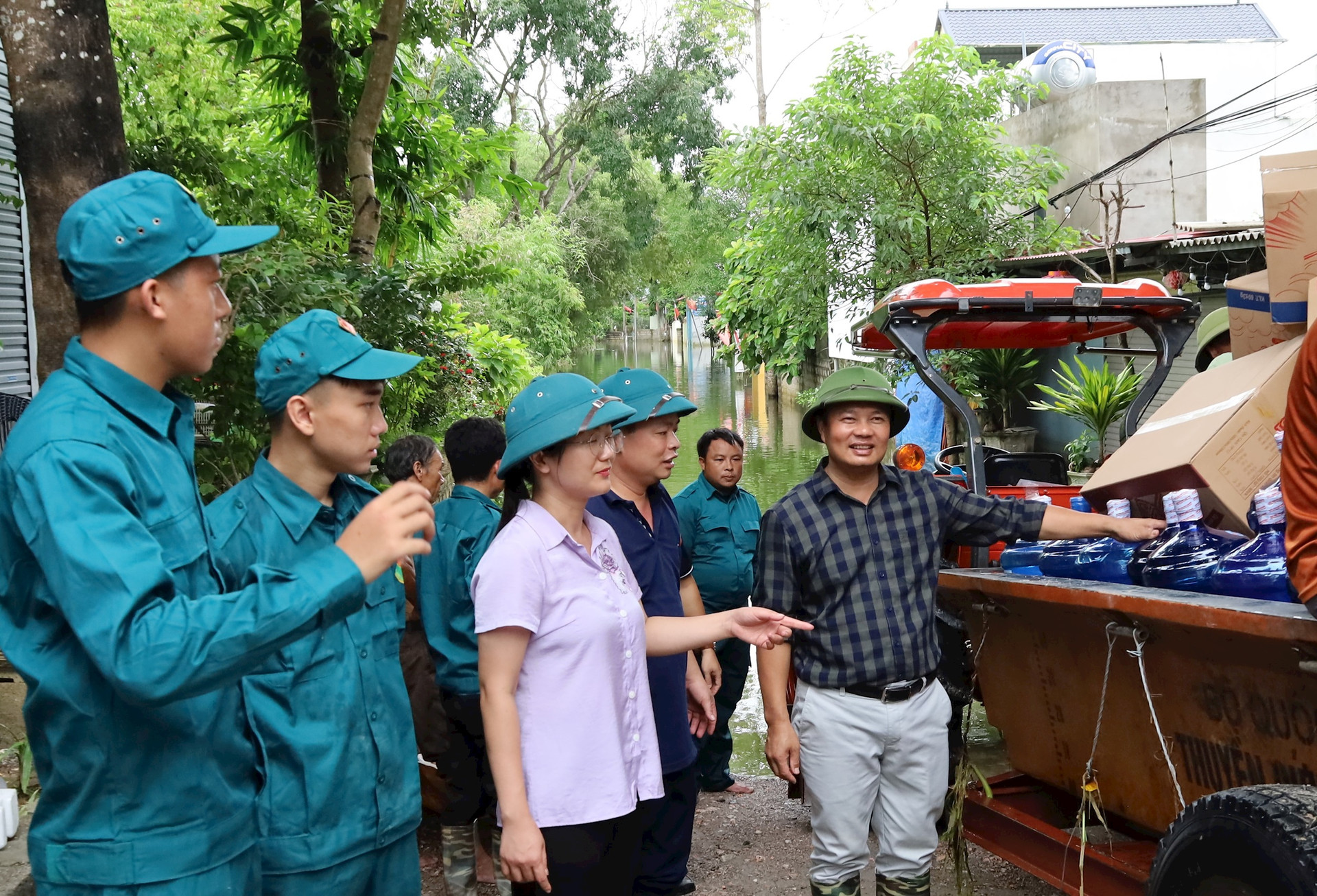 Xã Nam Phương Tiến (huyện Chương Mỹ) huy động lực lượng, phương tiện vận chuyển nhu yếu phẩm thiết yếu và quà cứu trợ đến người dân vùng bị nước lũ cô lập. Ảnh: Bảo Châu