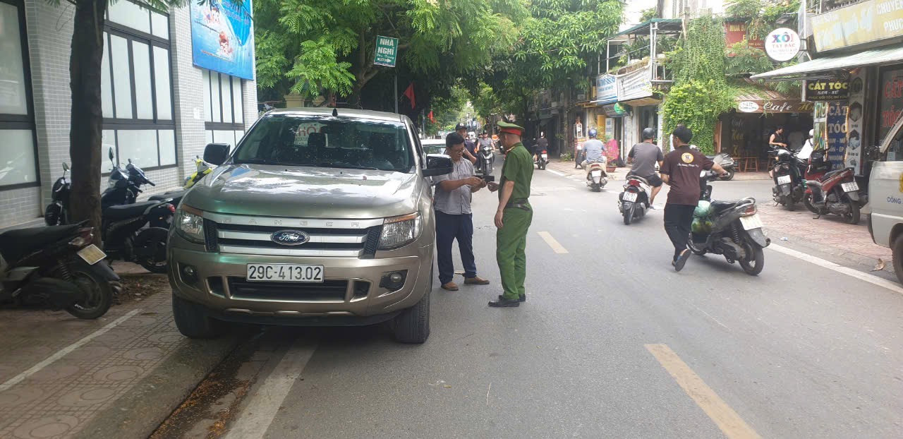 Công an phường Thành công tập trung xử lý vi phạm đỗ xe sai quy định trước cổng trường. Ảnh: VD