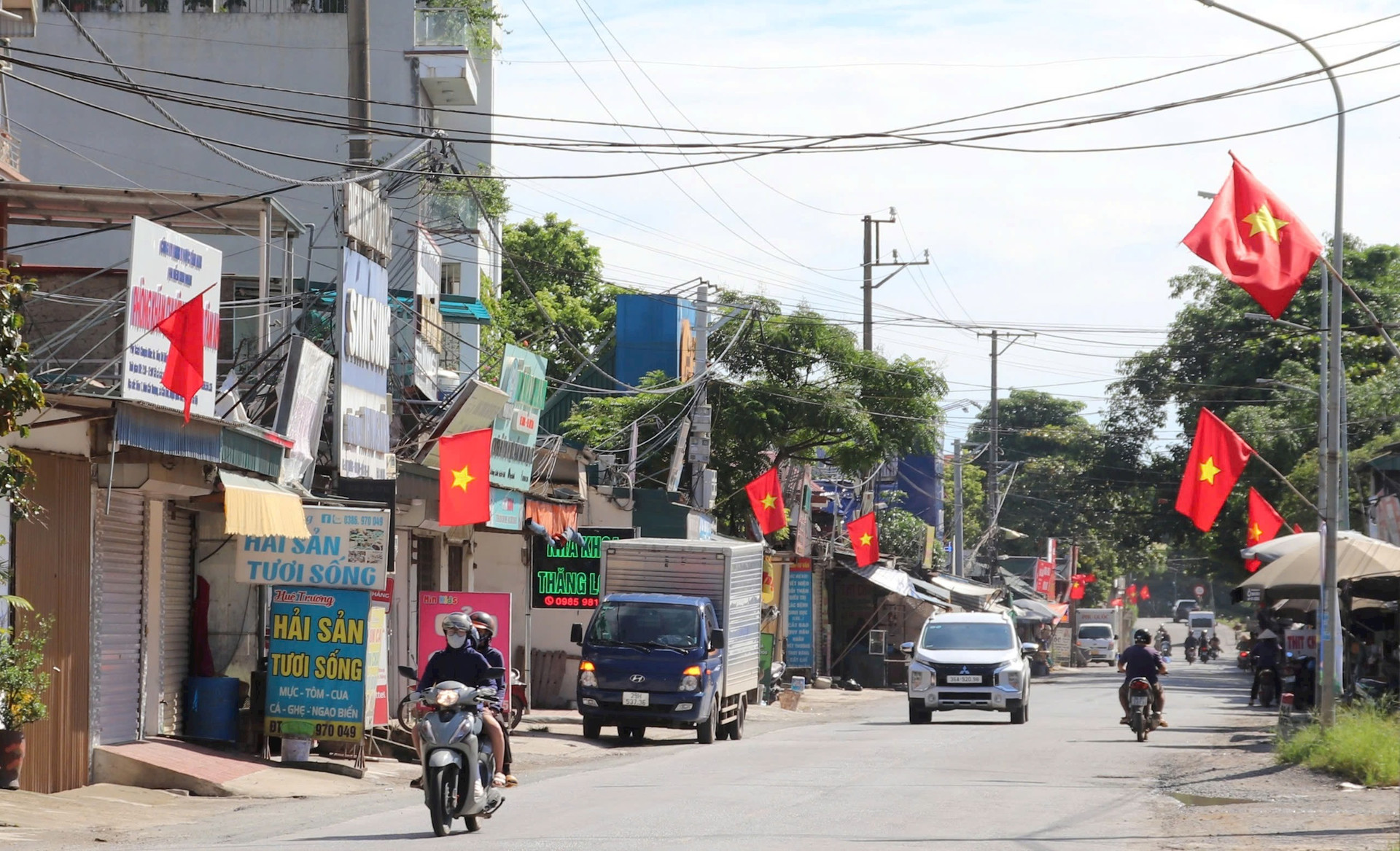 Ngoài dọn vệ sinh môi trường, sáng 31-8, trên các trục đường chính, ngõ xóm ở huyện Quốc Oai còn được treo cơ Tổ quốc, cờ hồng chào mừng 79 năm Cách mạng Tháng tám thành công và Quốc khánh 2-9. Ảnh: Hoàng Văn 