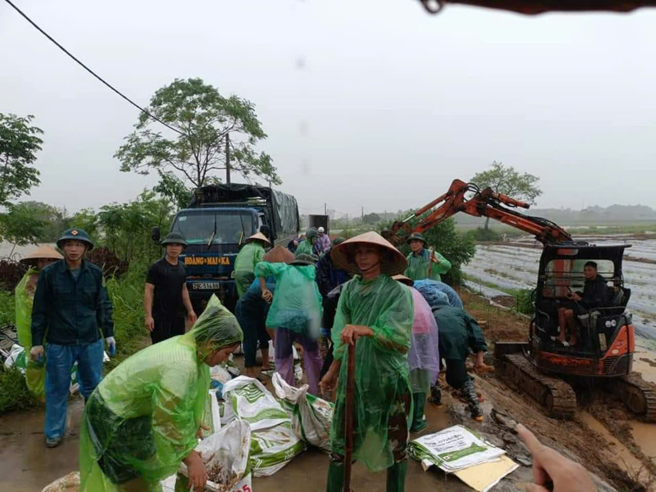 Người dân huy động cả máy xúc, ô tô hỗ trợ đất, đá nhằm đấy nhanh tiến độ việc việc công lũ lụt. Ảnh: Văn Nghĩa