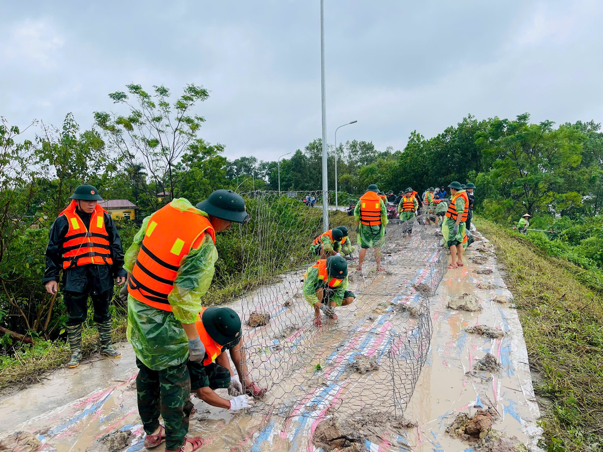 Các lực lượng của huyện Quốc Oai xử lý sự cố mặt đê tả Tích đoạn qua địa phận xã Ngọc Liệp. Ảnh: Thúy Nga