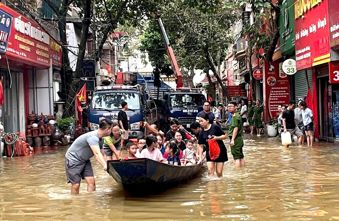 Thuyền của nhân dân xã Hương Sơn (huyện Mỹ Đức) giúp người dân xã Bát Tràng di chuyển khỏi nơi ngập lụt. Ảnh: Minh Nguyễn