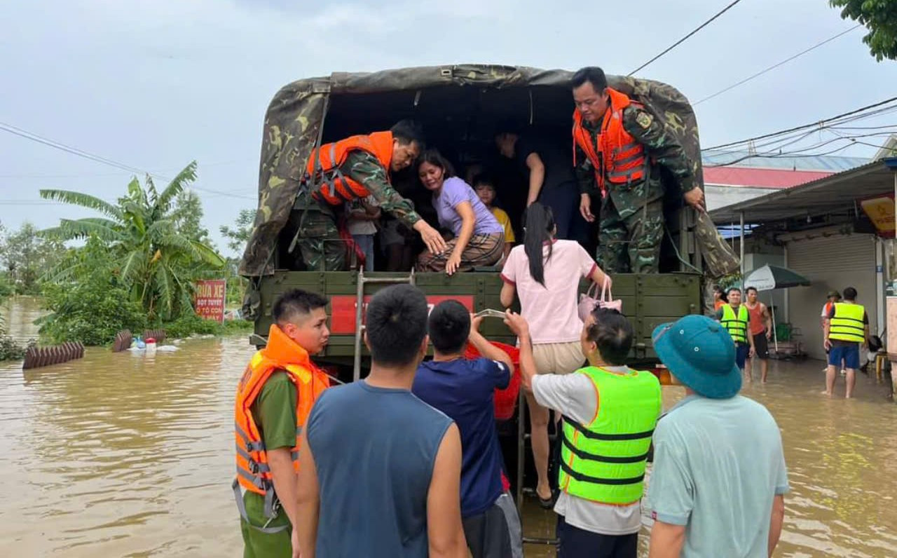 Cán bộ, chiến sĩ Lữ đoàn 971 hỗ trợ di chuyển người dân vùng lũ vào khu vực an toàn. Ảnh: Ngô Huân