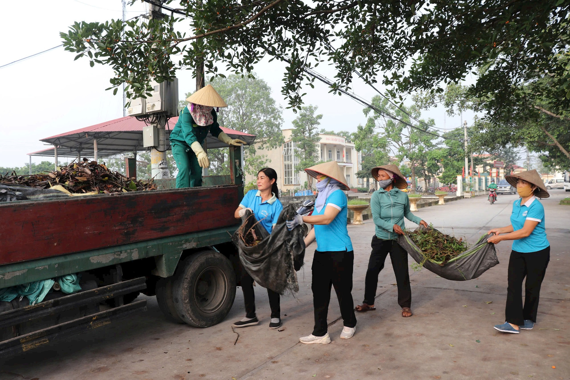 Công Ty Môi trường đô thị Xuân Mai điều động xe ô tô và công nhân phối hợp với các xã, thị trấn của huyện Quốc Oai vận chuyển, xử lý rác thải, cành cây gãy đổ sau bão. Ảnh: Hoàng Sơn