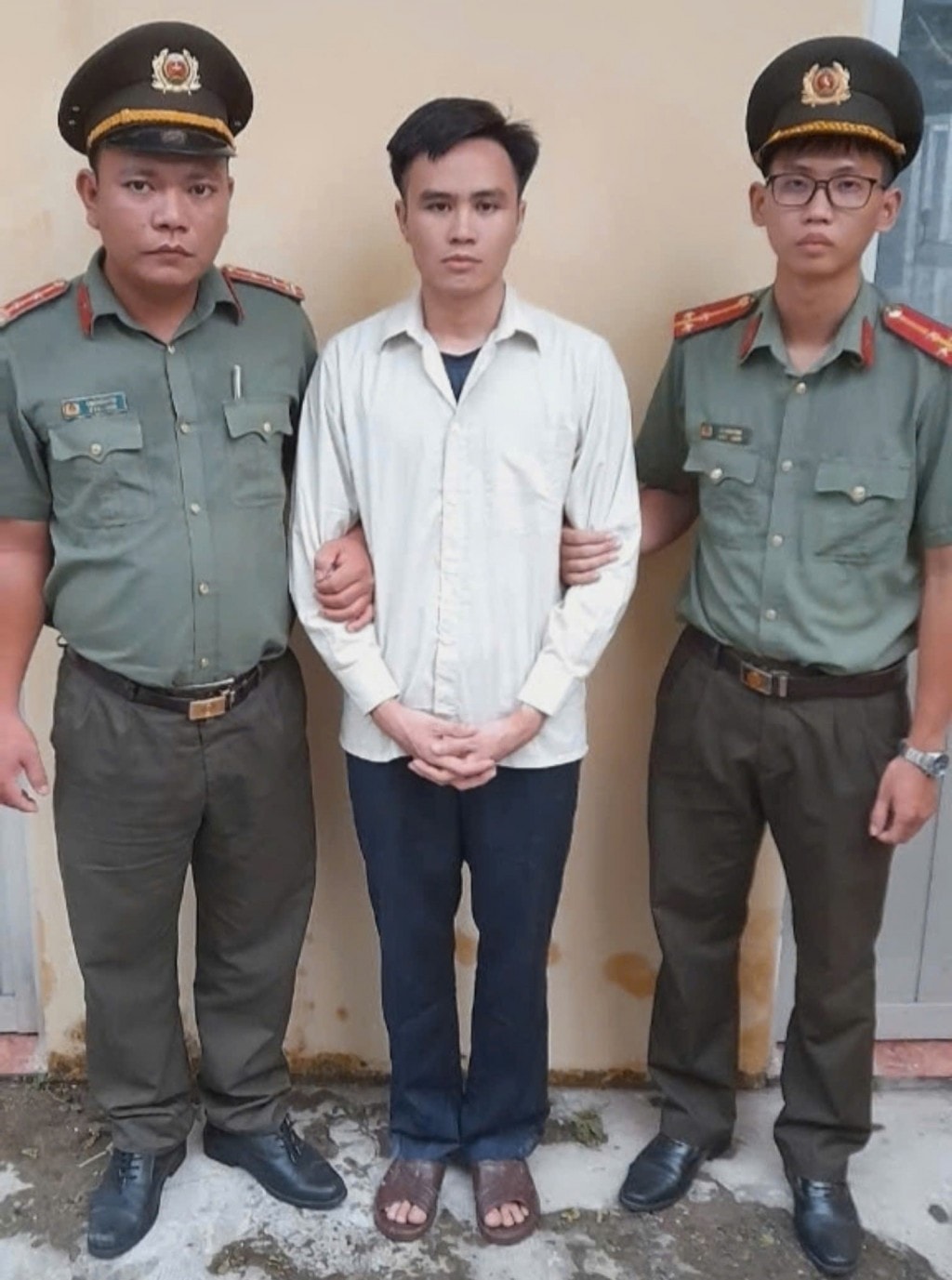 Đối tượng Trần Khắc Đức (giữa) tại cơ quan Công an