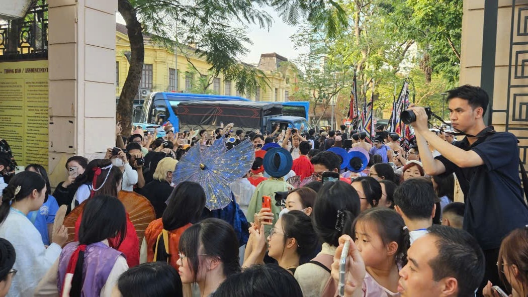 Đông đúc người dân đứng tại cổng bảo tàng để ngắm nhìn đoàn diễu hành đi qua. 