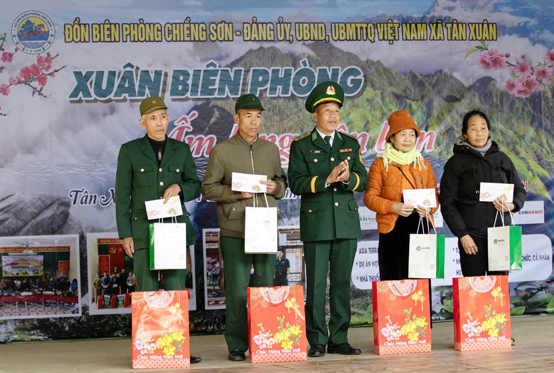 ANH: Trung tá Lò Văn Sáng, Phó Đồn trưởng Đồn Biên phòng Chiềng Sơn tặng quà bốn hộ gia đình chính sách ở xã Tân Xuân. Ảnh: NSNA Đức Kiên