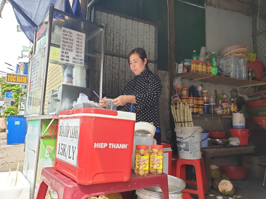 Chị Loan bên cửa hàng trái cây đã giúp chị thoát nghèo