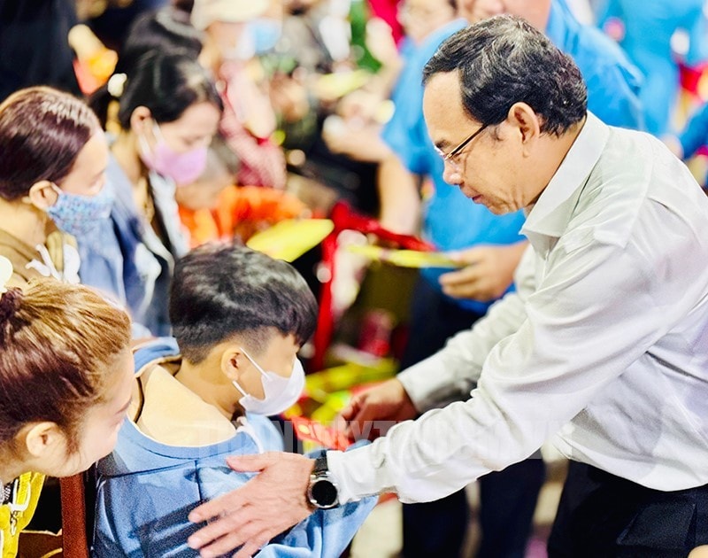 Bí thư Thành ủy TPHCM Nguyễn Văn Nên trao quà cho các cháu nhỏ là con công nhân có hoàn cảnh khó khăn trước khi lên đường về quê đón Tết - Ảnh: Thành ủy TPHCM