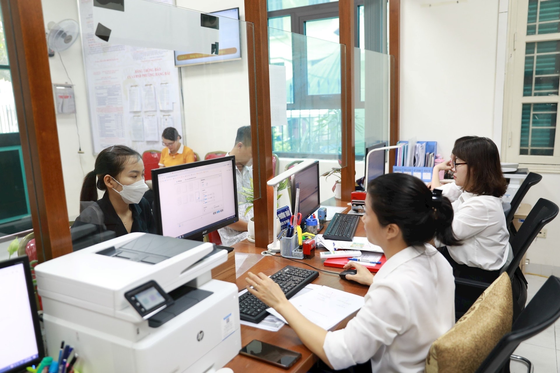 Cán bộ phường Hàng Bài (quận Hoàn Kiếm) thực hiện thủ tục hành chính cho người dân. Ảnh: Quang Thái