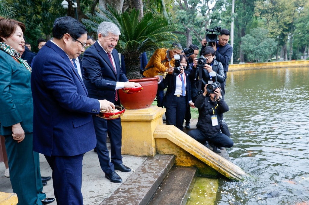 Hai Thủ tướng thăm ao cá Bác Hồ nằm ngay trước khuôn viên nhà sàn và cho cá ăn - Ảnh: VGP/Nhật Bắc