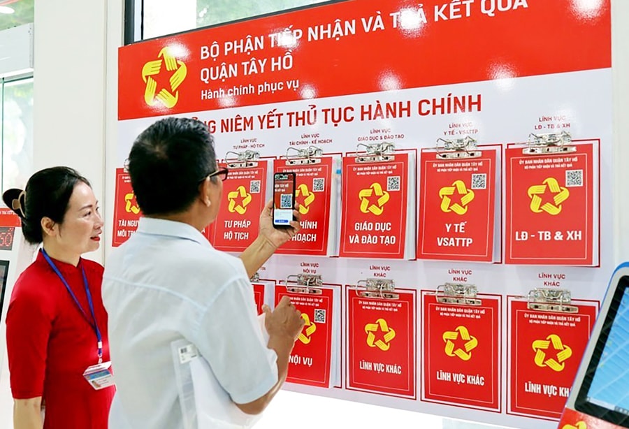 Cán bộ bộ phận một cửa quận Tây Hồ hướng dẫn người dân sử dụng hỗ trợ dịch vụ công trực tuyến và tương tác với chính quyền qua nền tảng số.