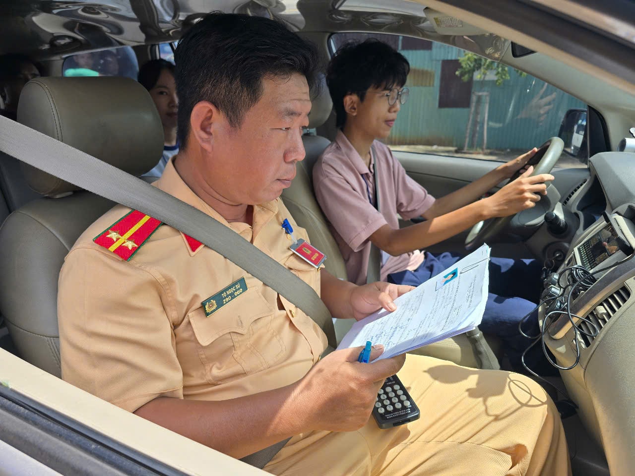 Lực lượng Cảnh sát giao thông giám sát thí sinh đang tham gia phần thi sát hạch lái xe trên đường. Ảnh Nghiêm Ý.