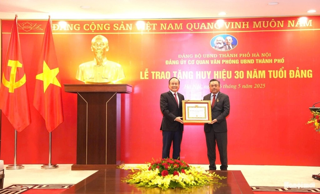 Phó Bí thư Thành uỷ, Chủ tịch HĐND thành phố Nguyễn Ngọc Tuấn trao Huy hiệu 30 năm tuổi Đảng tặng đồng chí Trần Sỹ Thanh. Ảnh: Đình Hiệp