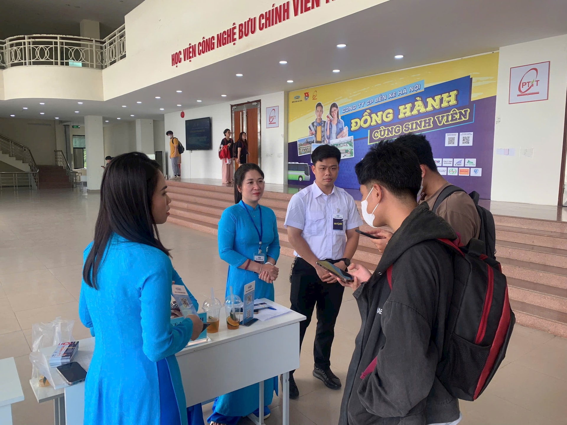 Nhân viên bến xe hướng dẫn sinh viên quét mã QR để tra cứu tuyến xe, giờ xe tại các bến xe Giáp Bát, Mỹ Đình, Gia Lâm. Ảnh: Tuấn Khải.