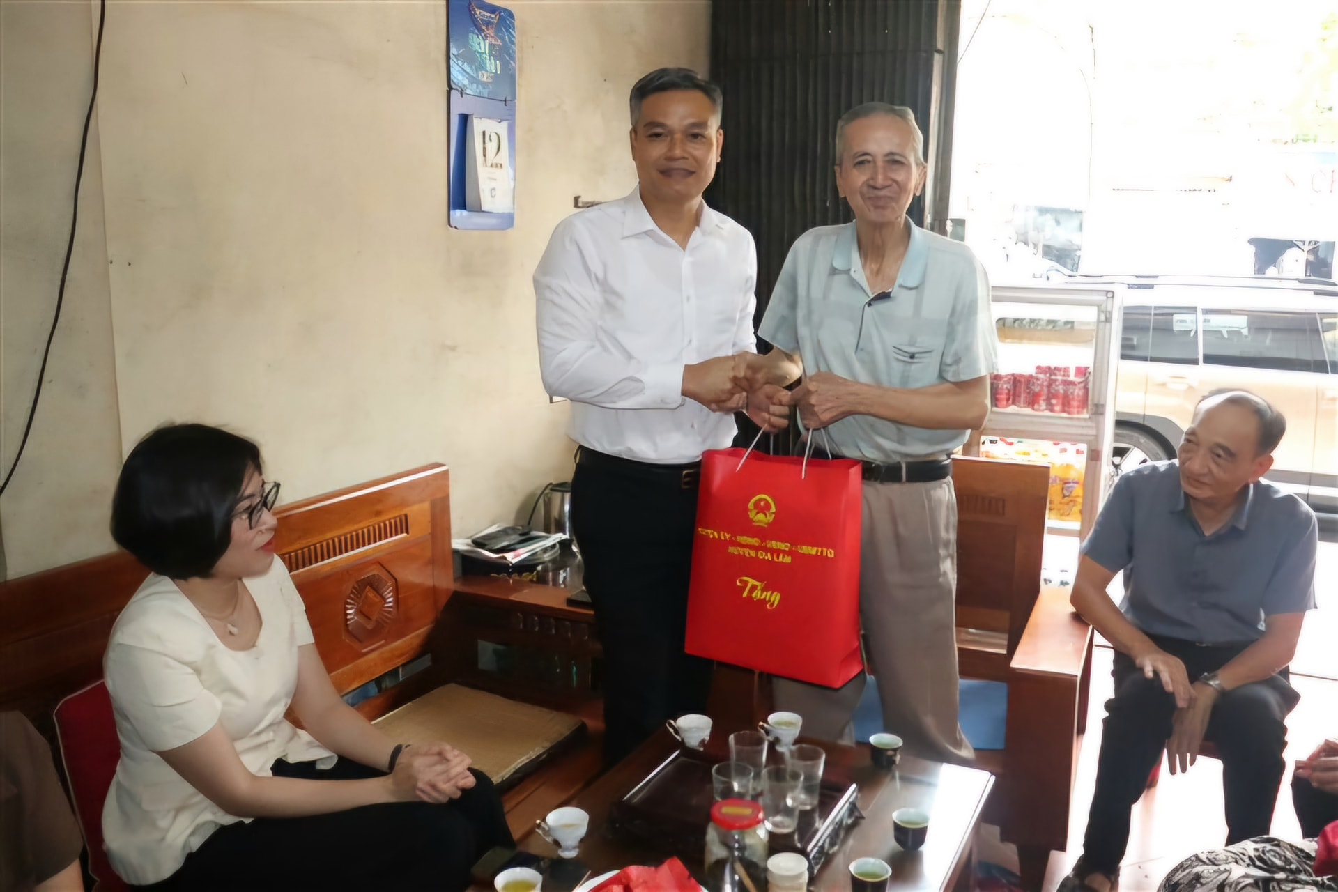 Lãnh đạo huyện Gia Lâm tặng quà ông Nguyễn Văn Thông- người hoạt động kháng chiến bị nhiễm chất độc hóa học cư trú tại thị trấn Yên Viên. Ảnh: Vân Thư
