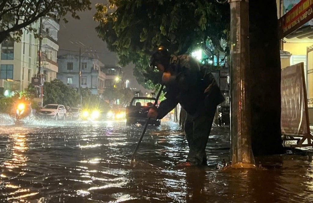 Lực lượng chức năng khơi thông cống rãnh, thoát nước (Ảnh Đ.Minh)