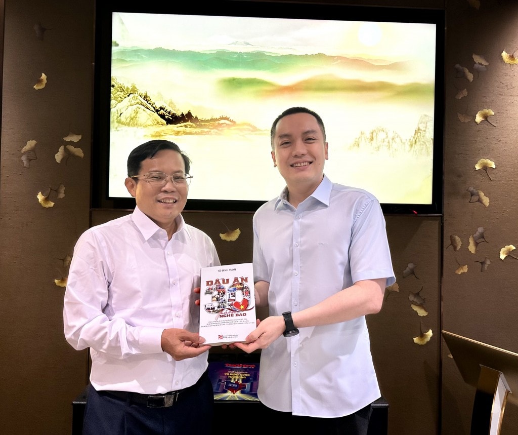 Nhà báo Tô Đình Tuân (bên trái) tặng sách nhà báo Lưu Quang Định, Nguyên TBT Báo Nông thôn Ngày nay/Dân việt.