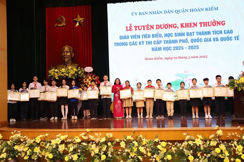 Nhà giáo Trịnh Ngọc Trâm - Trưởng phòng GD&ĐT quận Hoàn Kiếm trao thưởng cho các em học sinh đạt giải thưởng xuất sắc trong các kỳ thi quốc tế và thành phố