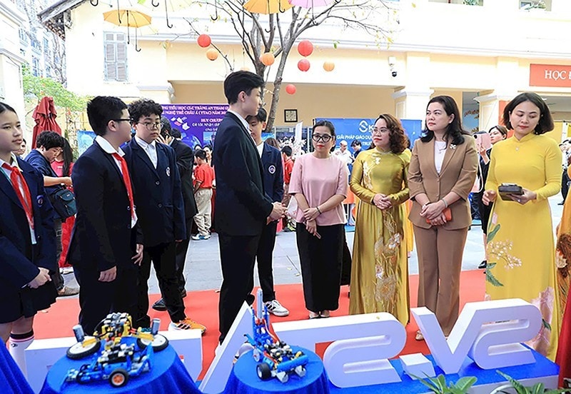 Các đại biểu nghe các em học sinh giới thiệu những phần mềm dự thi tại Tuần lễ chuyển đổi số