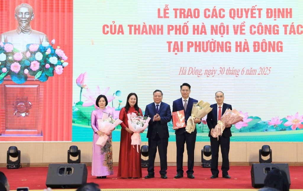 Phó Bí thư Thường trực Thành ủy Hà Nội Nguyễn Văn Phong trao quyết định công tác cán bộ và tặng hoa chúc mừng lãnh đạo HĐND phường Hà Đông. Ảnh: Quang Thái