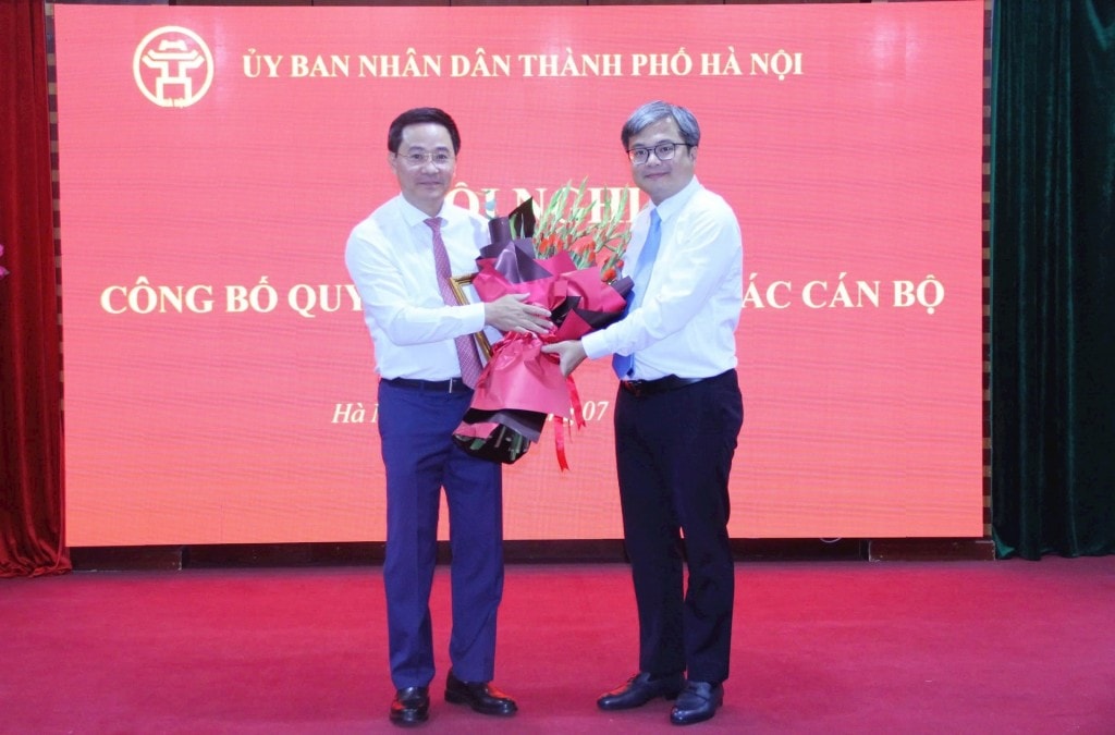 Phó Chủ tịch UBND thành phố Trương Việt Dũng trao quyết định bổ nhiệm và tặng hoa tân Giám đốc Sở Khoa học và Công nghệ Trần Anh Tuấn. Ảnh: Đỗ Minh