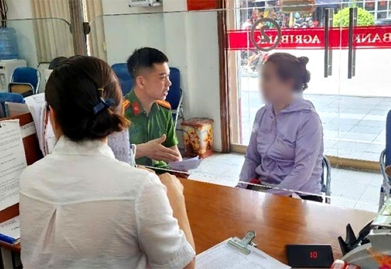 Cán bộ công an và nhân viên ngân hàng giải thích cho bà T về thủ đoạn của các đối tượng lừa đảo