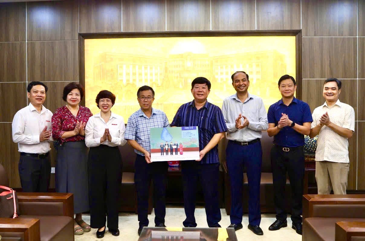 និពន្ធនាយករងនៃកាសែត Hanoi Moi លោក Lai Ba Ha បង្ហាញរូបថតអនុស្សាវរីយ៍ដល់ថ្នាក់ដឹកនាំវួដ Tay Ho។ រូបថត៖ Nguyen Anh