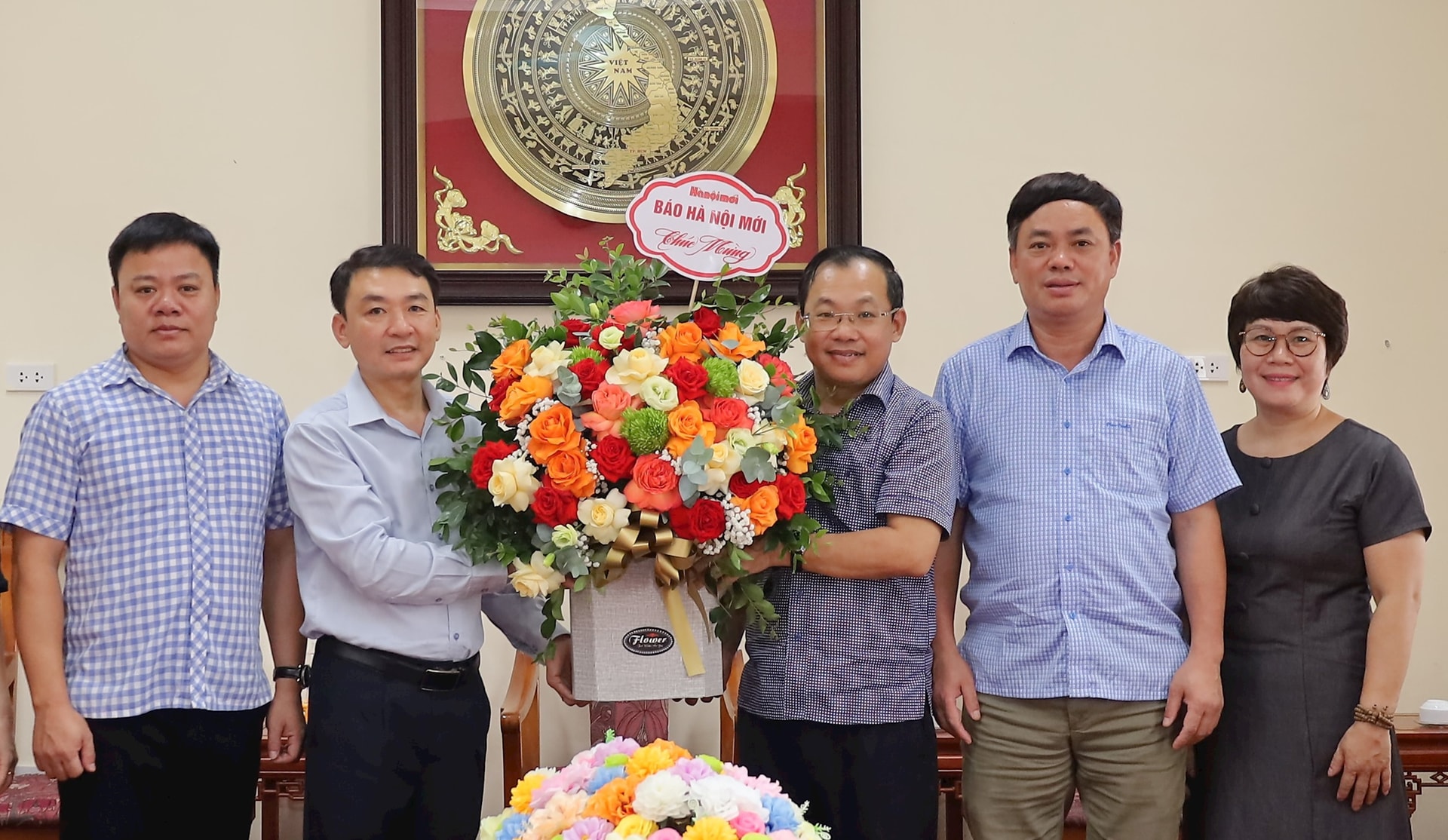 Đoàn công tác Báo Hànộimới tặng hoa chúc mừng đại diện lãnh đạo Đảng ủy, HĐND, UBND, MTTQ Việt Nam xã Xuân Mai mới thành lập theo mô hình chính quyền địa phương hai cấp. Ảnh: Kim Nhuệ