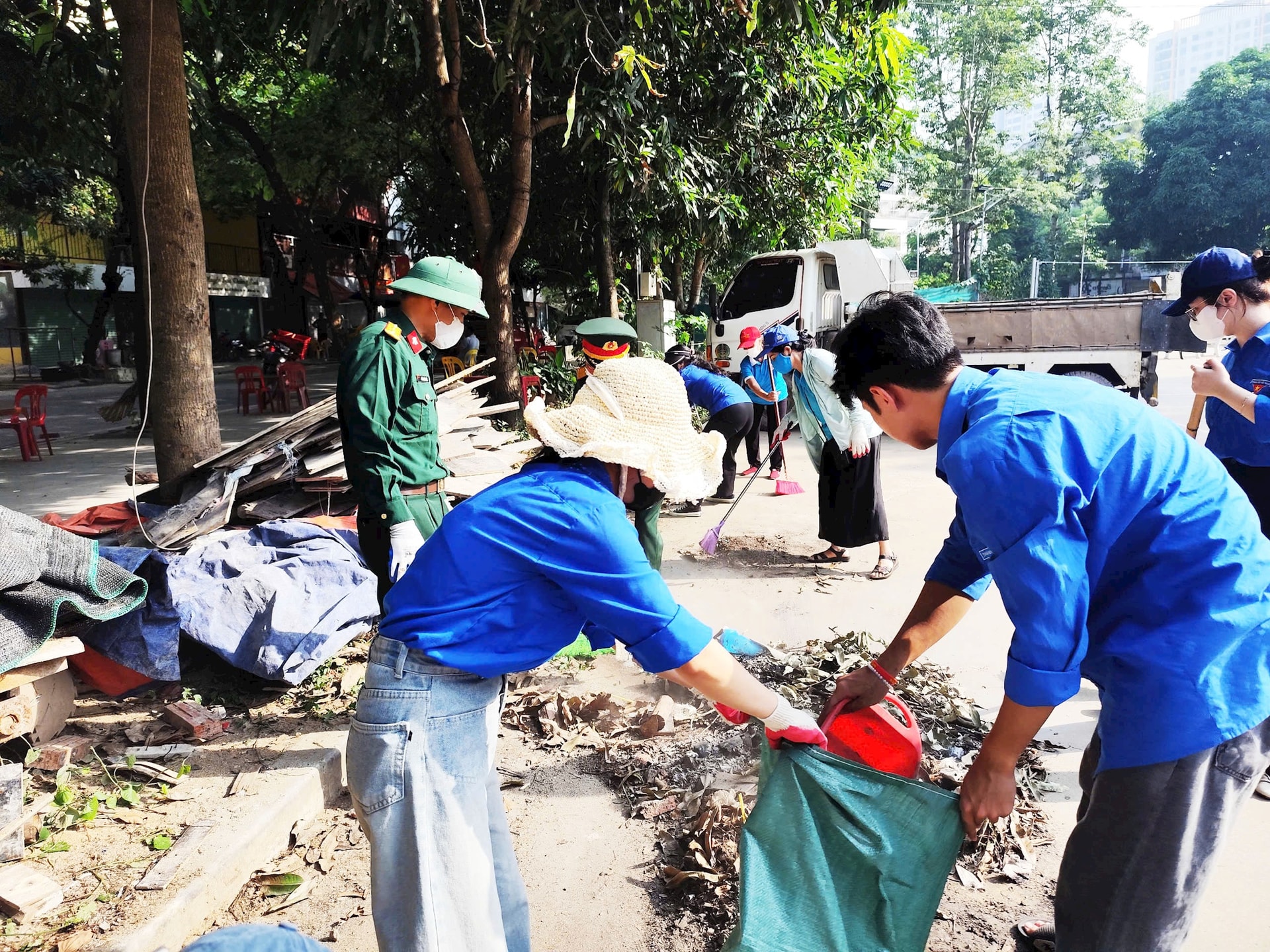 Các đoàn viên thanh niên hăng hái thu gom rác thải, lá khô dọc vỉa đường, cùng chung tay xây dựng cảnh quan đô thị văn minh.