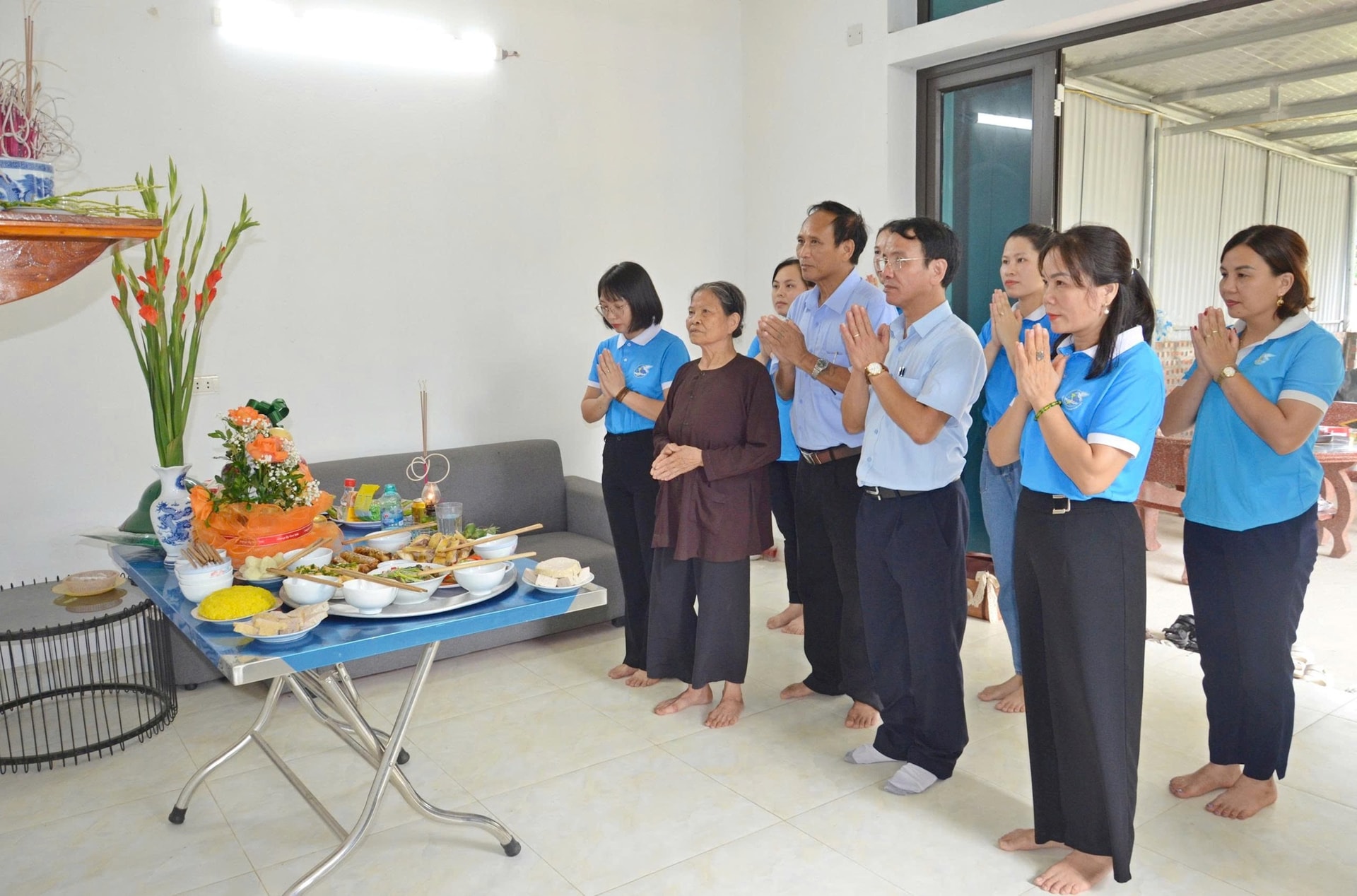 Các hội.viên phụ nữ phường Tùng Thiện thực hiện “Mâm cơm tri ân” tại gia đình bà Lê Thị Kết - vợ liệt sỹ Trương Văn Vị. Ảnh: Phan Thanh