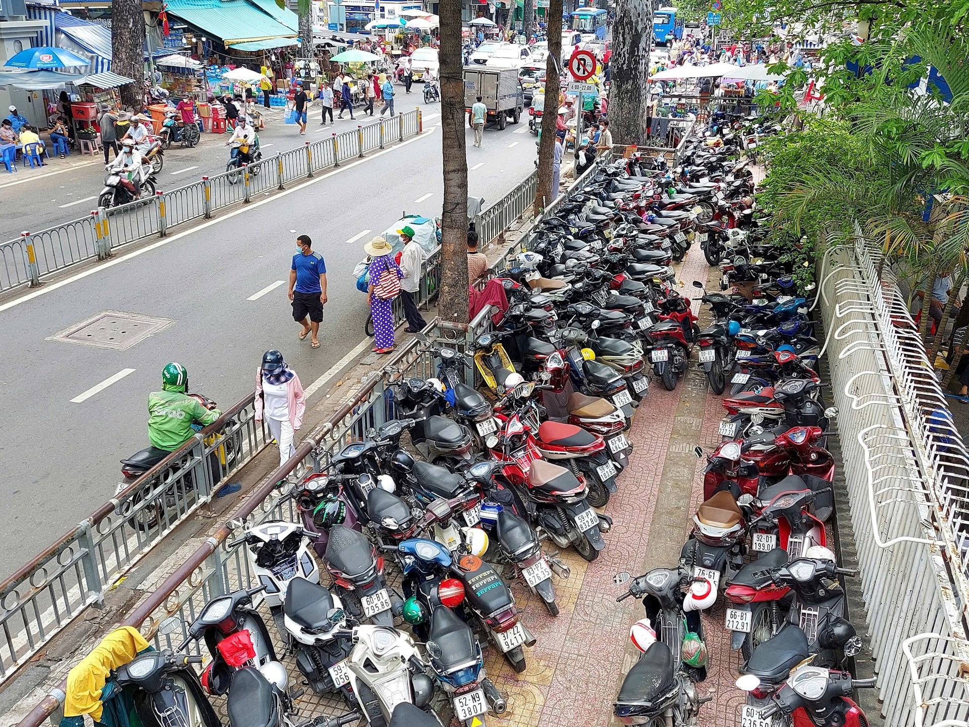 Bãi giữ xe gắn máy lấn chiếm trọn vỉa hè đường Nguyễn Chí Thanh, thành phố Hồ Chí Minh. Ảnh: Hà Tuấn