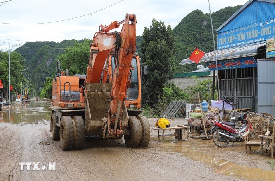 Máy cẩu được huy động tham gia giải phóng các điểm ngập trên quốc lộ 7. (Ảnh: Xuân Tiến/TTXVN)