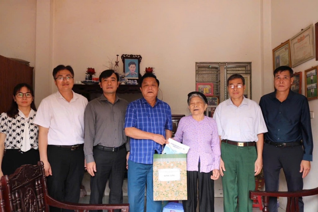 Đồng chí Chủ tịch UBND xã Trần Thanh Hoài cùng các đồng chí trong đoàn công tác thăm tặng quà Mẹ liệt sỹ Nguyễn Thị Tâm.
