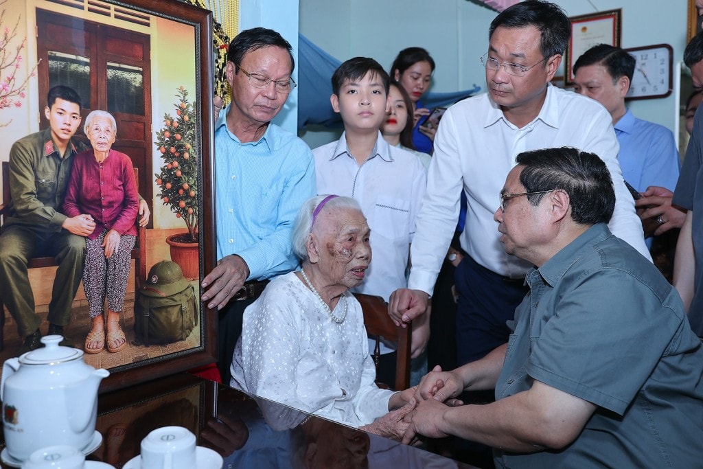Thủ tướng và đoàn công tác đã kính tặng Mẹ Đào Thị Vui những bức ảnh, đoạn phim tái hiện hình ảnh Mẹ bên người con trai duy nhất, được thực hiện bằng công nghệ trí tuệ nhân tạo (AI) - Ảnh: VGP/Nhật Bắc