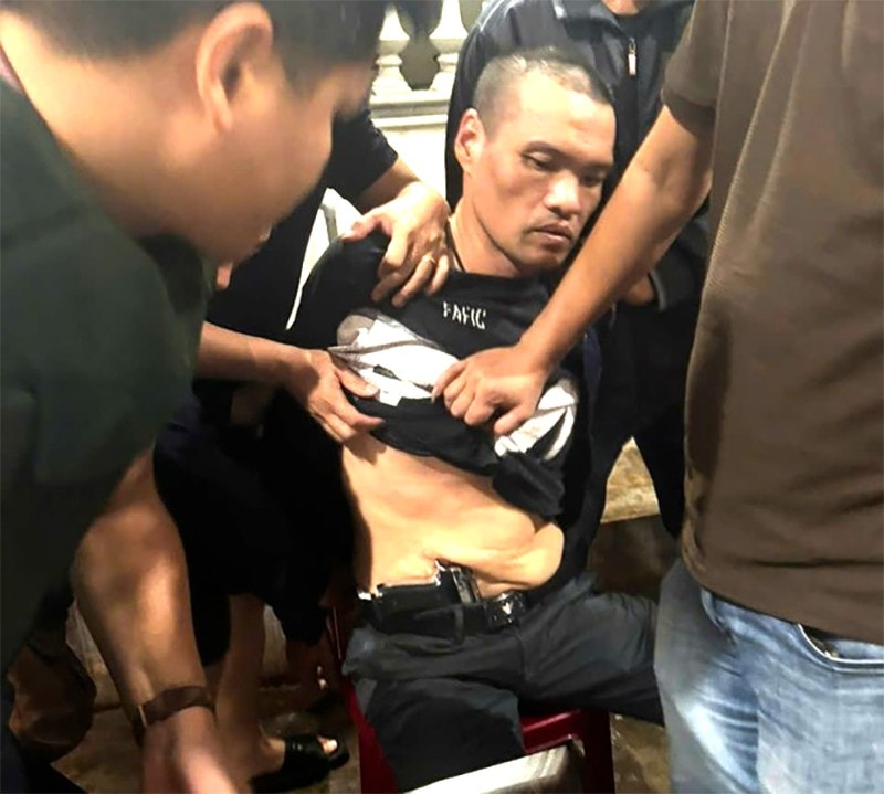 Các trinh sát khống chế Trần Hải Quỳnh cùng tang vật là khẩu súng quân dụng giấu trong người