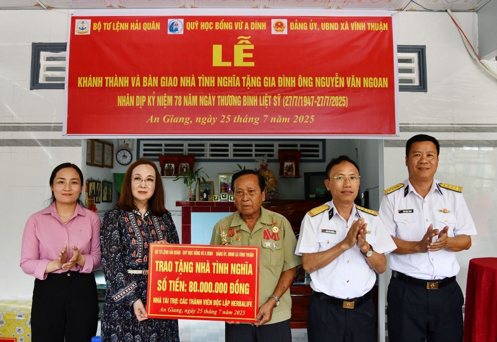 Đại diện nhà tài trợ và thủ trưởng Bộ Tư lệnh Vùng 5 Hải quân trao biển tượng trưng số tiền hỗ trợ xây dựng nhà tình nghĩa tặng gia đình ông Ngoan