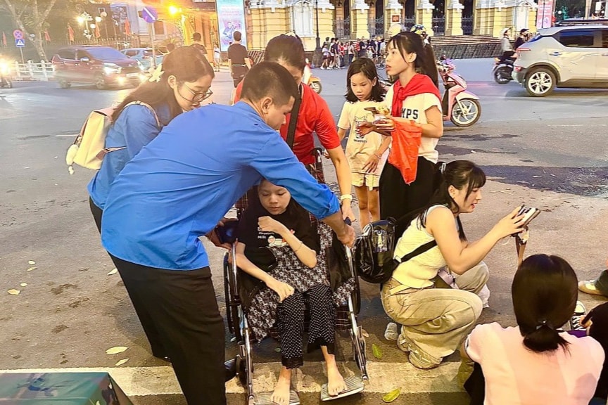 Các bạn trẻ hỗ trợ người dân đến xem chương trình tổng hợp luyện diễu binh, diễu hành 